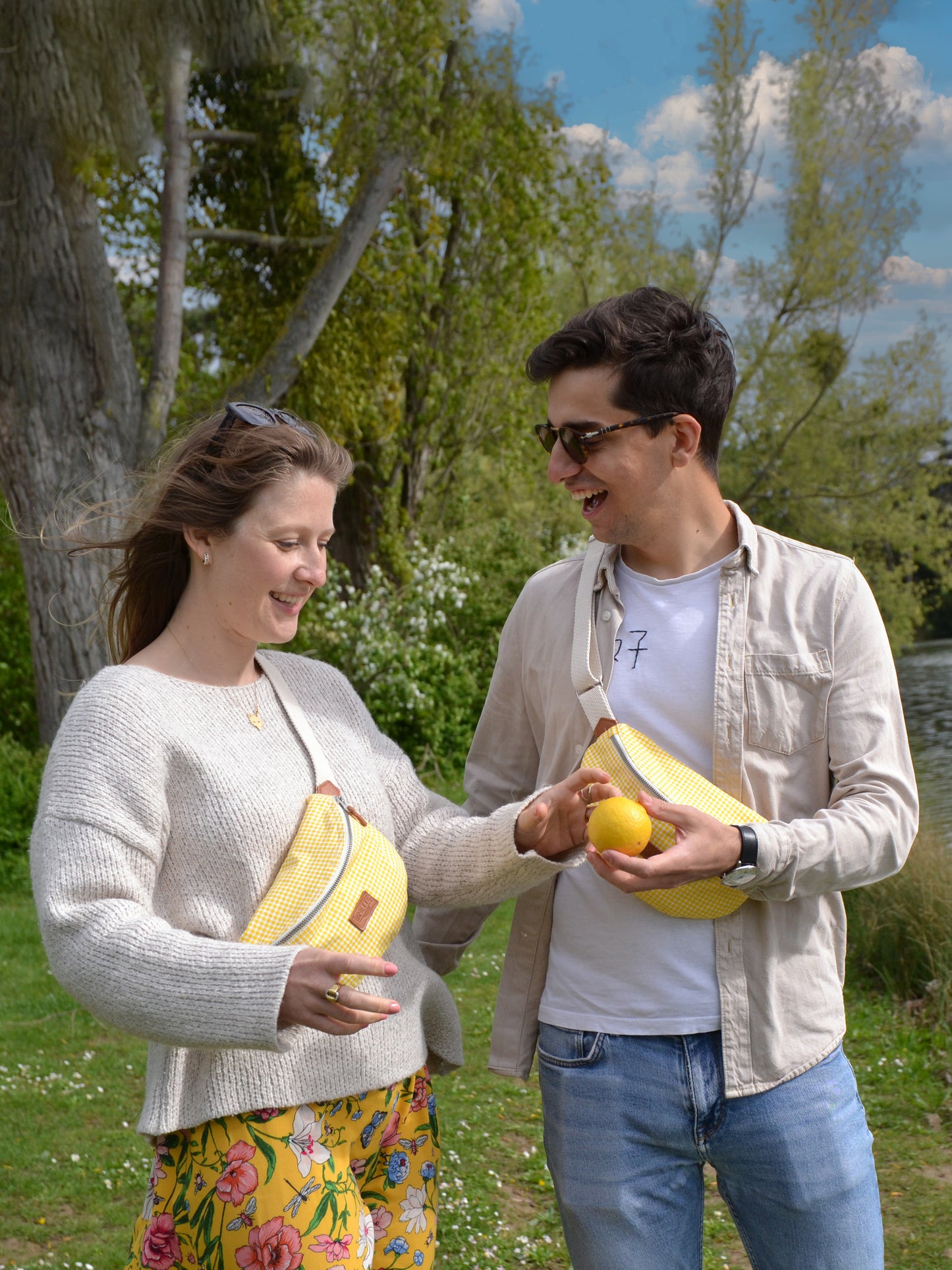 Jeune femme blonde et jeune homme brun portant des sacs banane binette écoresponsables jaunes motif vichy faits par une marque française.
