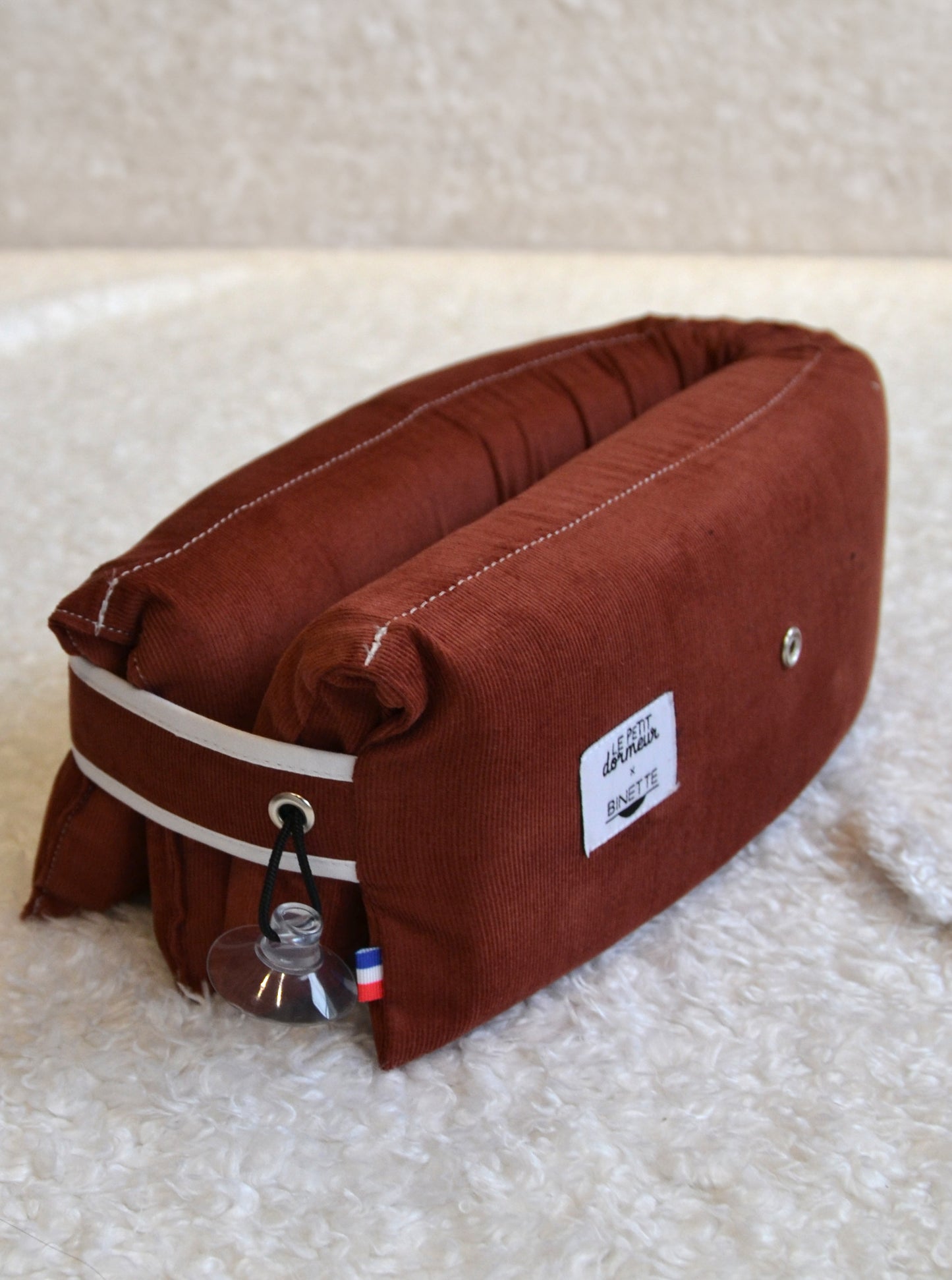 Coussin de voyage en velours côtelé rouge écoresponsable et fabriqué en France à mettre en 3 positions différentes pour voyager de manière responsable.