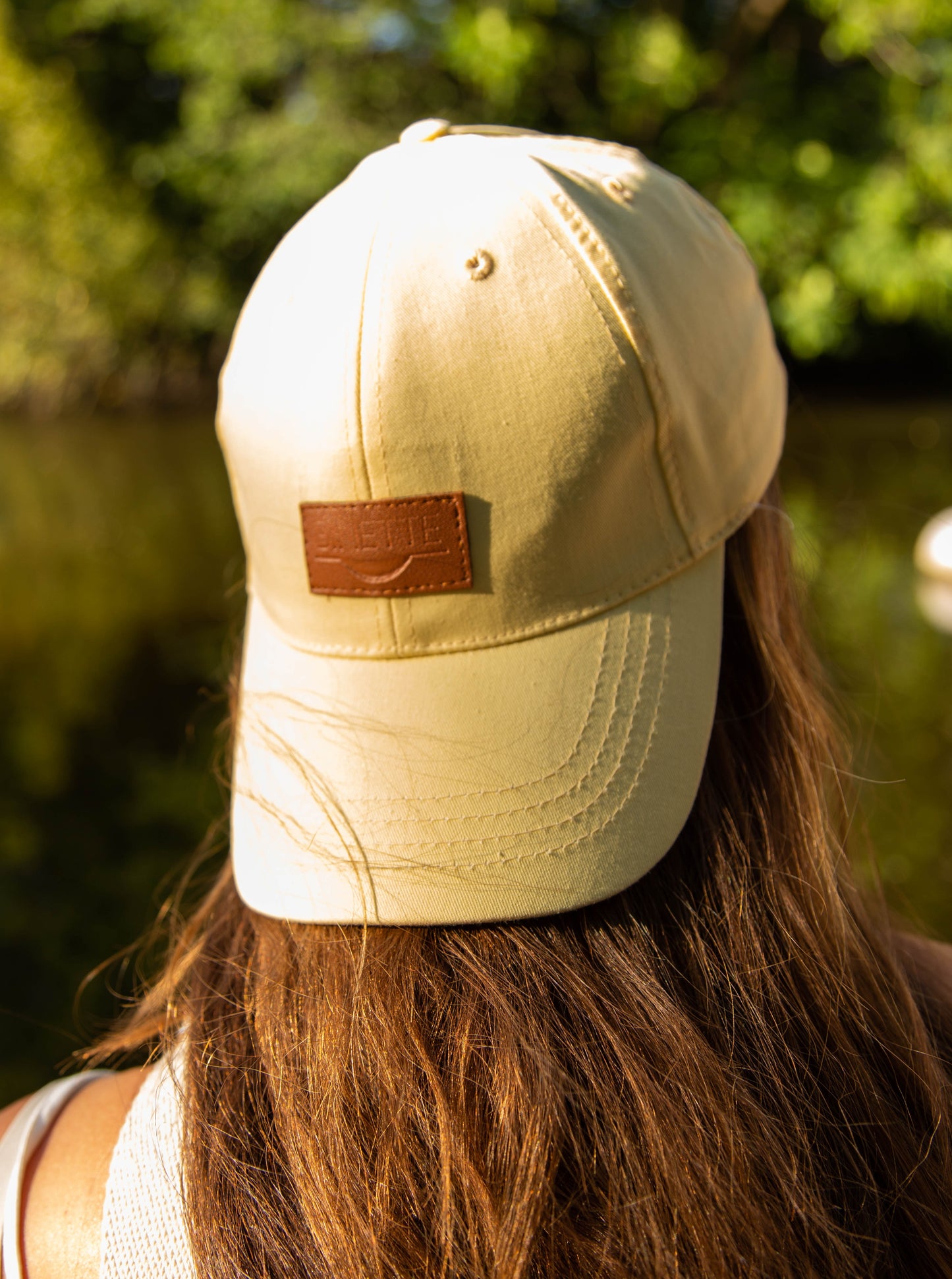 casquette jaune citron fabriquée en matière éco-responsable photo prise par Binette sur un mannequin femme de dos au bord d'un lac en été