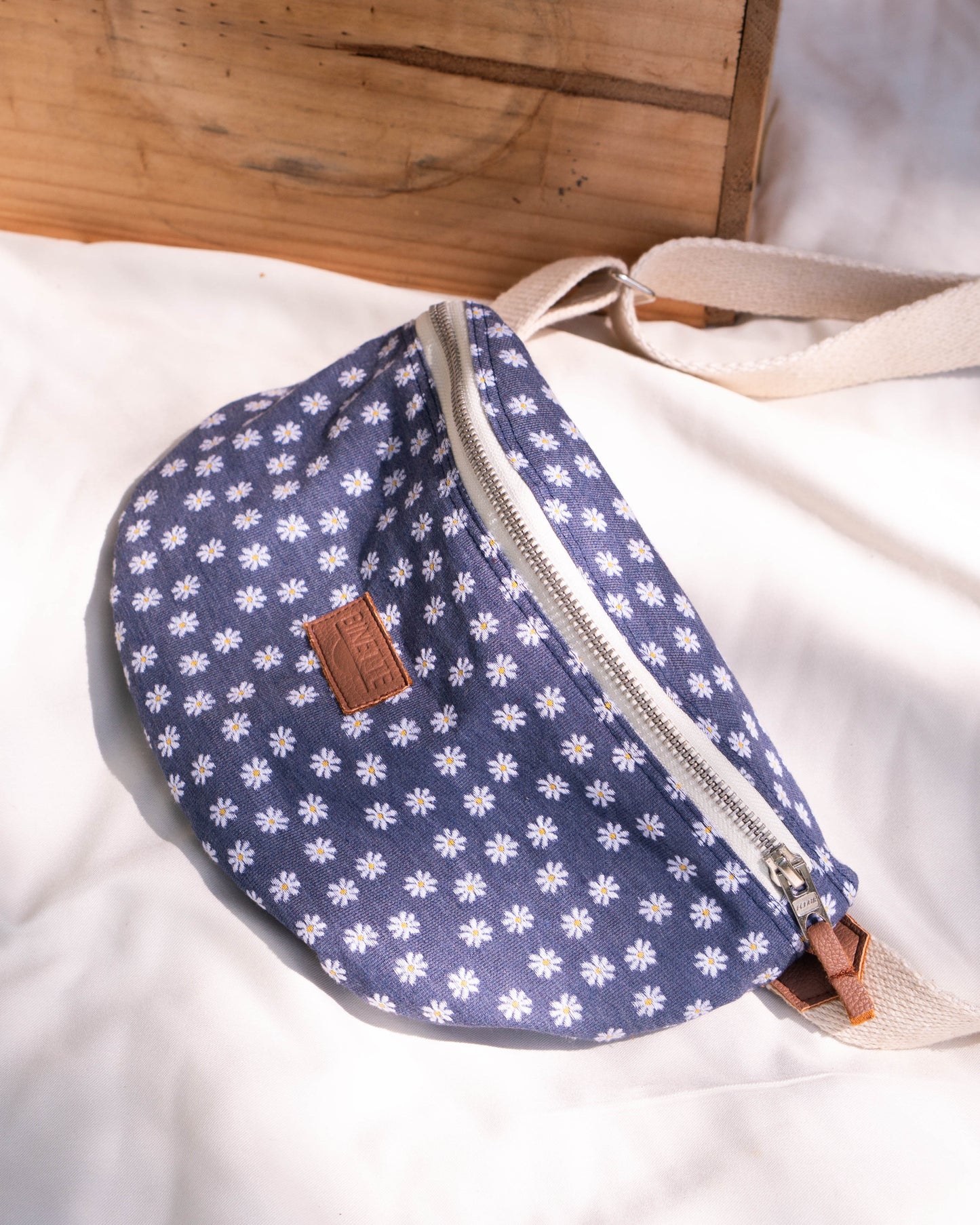 Packshot d'un sac banane bleu marine à fleur marguerite beige écoresponsable et recyclé sur un fond blanc parfaite pour idée cadeau femme et jeune maman