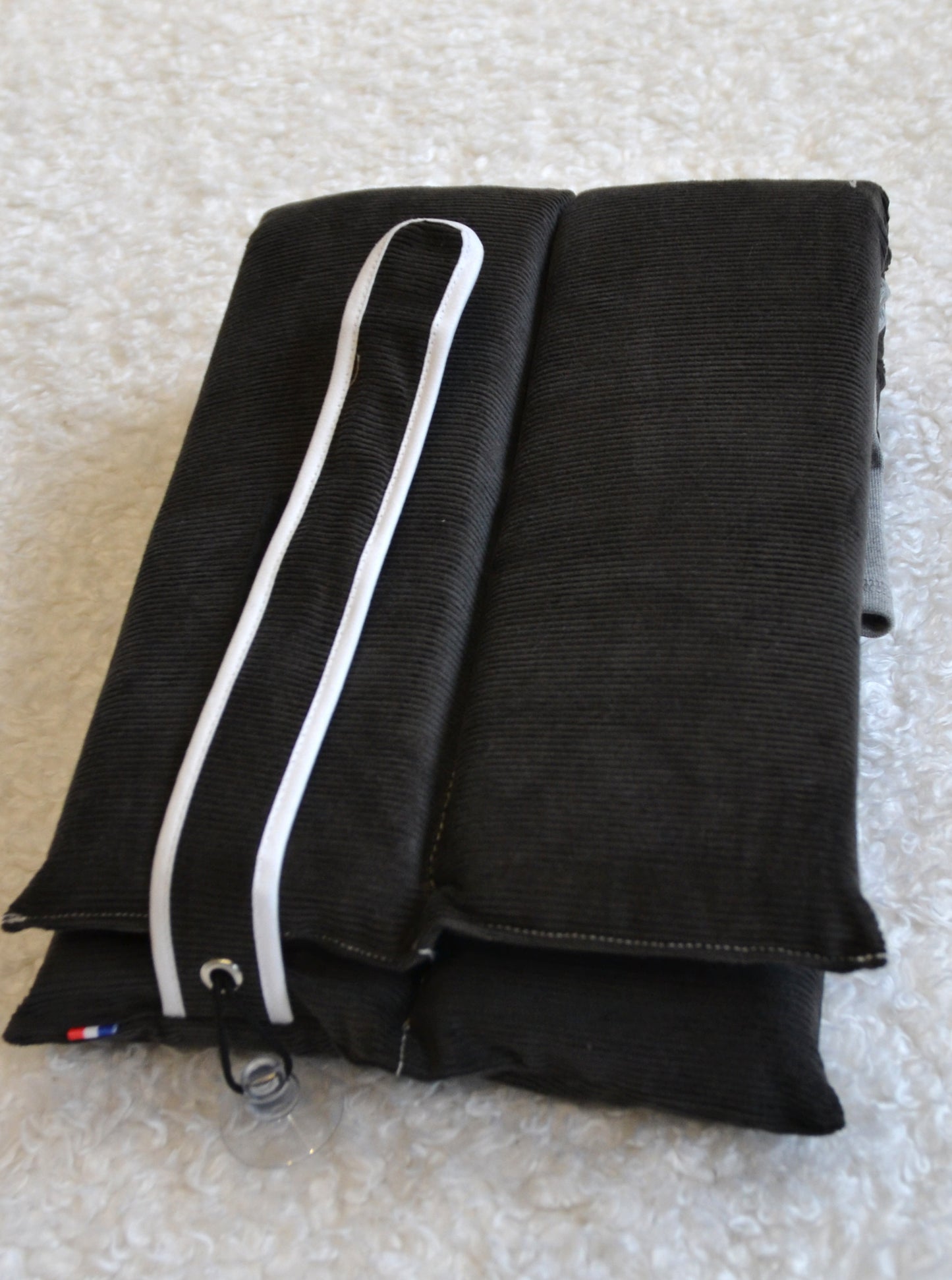 Coussin gris velours côtelé à plat, utilisation multiple.