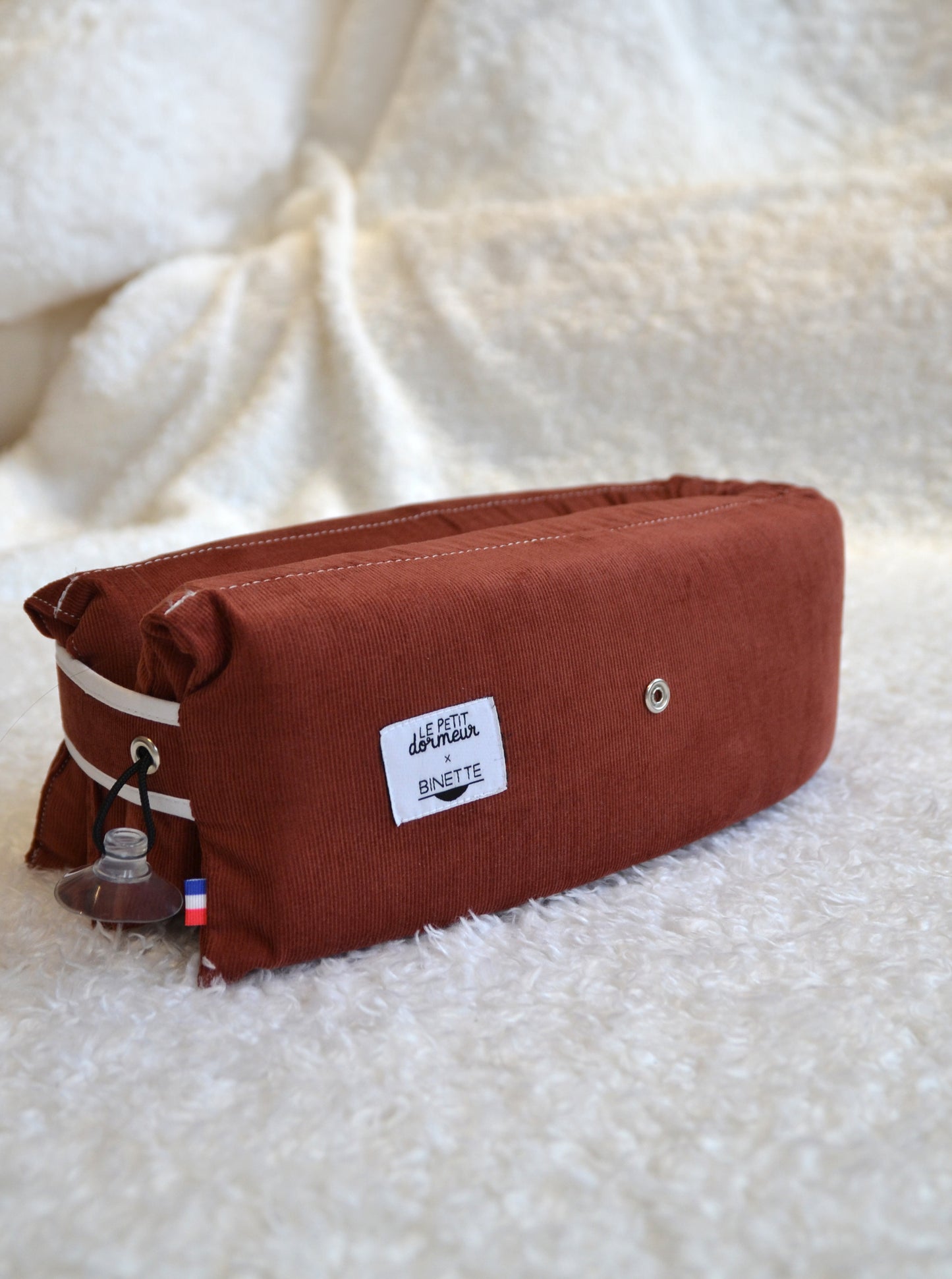 Coussin de voyage en velours côtelé rouge écoresponsable et fabriqué en France à mettre en 3 positions différentes pour voyager de manière responsable.