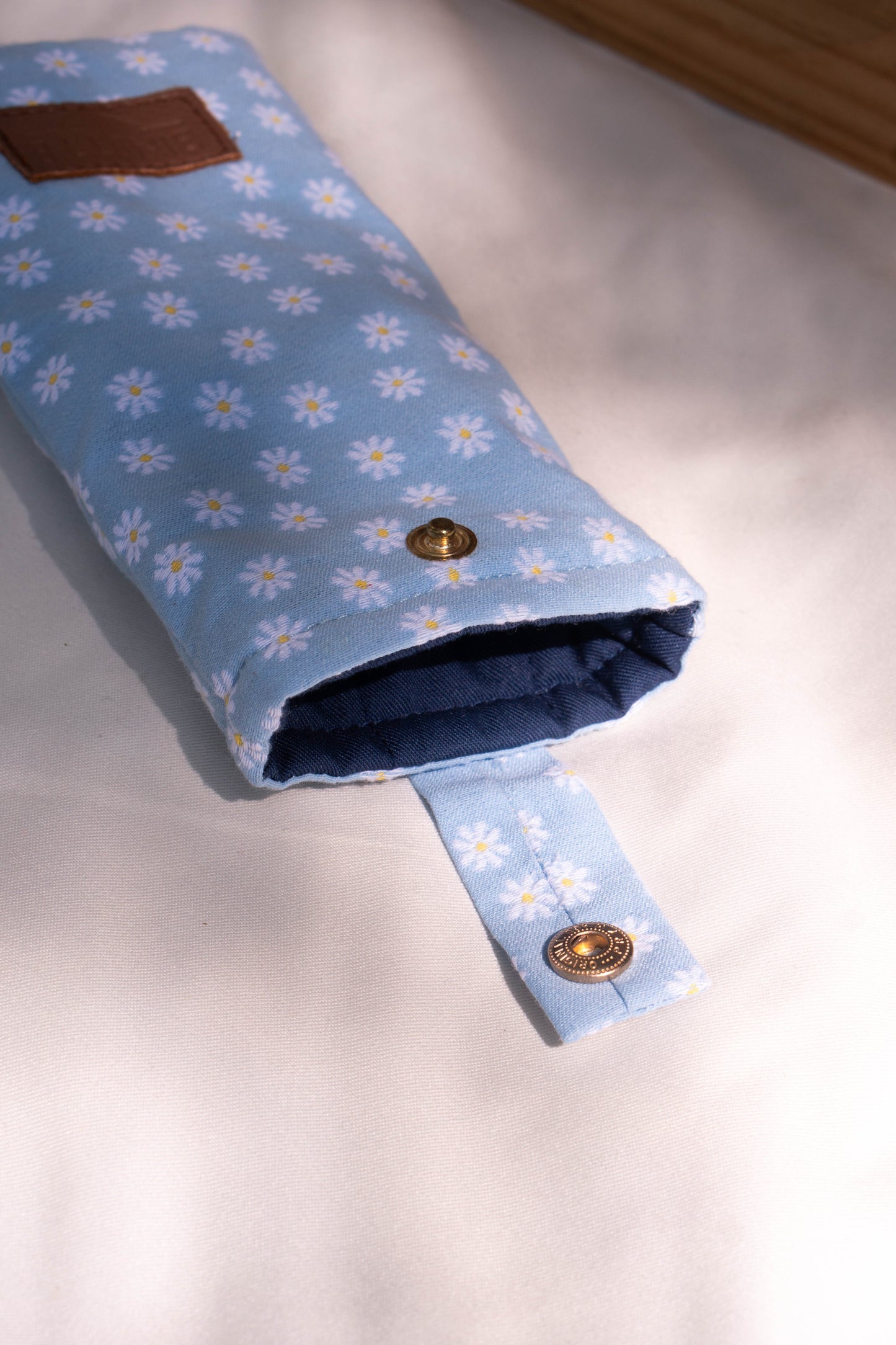 Packashot avec l'étui à lunettes bleu ciel marguerites. Design raffiné et détails soignés qui ajoutent une touche de sophistication à la protection de vos lunettes.