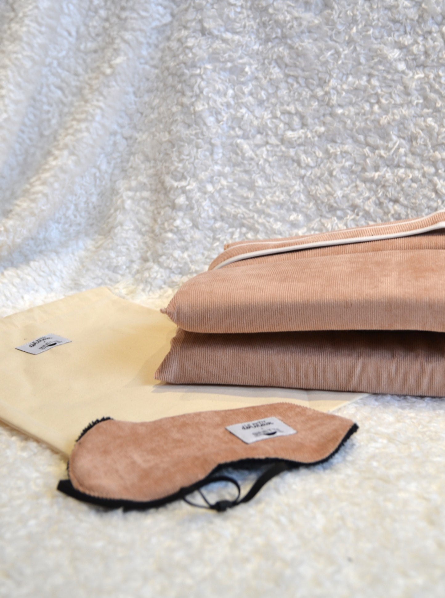 Zoom sur le pack sommeil composĂ© d'un coussin de voyage ergonomique en velours cĂŽtelĂ© rose clair et dâun masque de sommeil assorti, cet ensemble est conçu pour un confort optimal tout en respectant lâenvironnement.