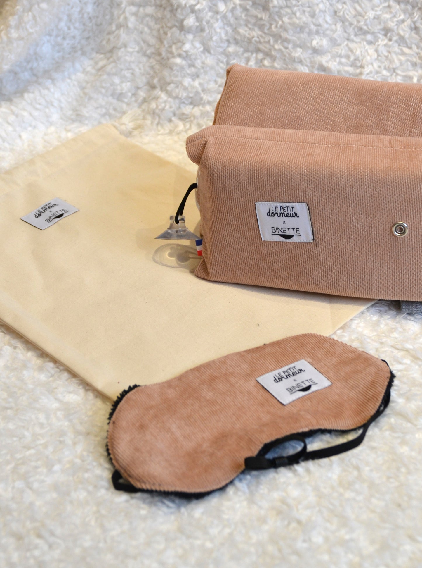 Zoom sur le pack sommeil composĂ© d'un coussin de voyage ergonomique en velours cĂŽtelĂ© rose clair et dâun masque de sommeil assorti, cet ensemble est conçu pour un confort optimal tout en respectant lâenvironnement.
