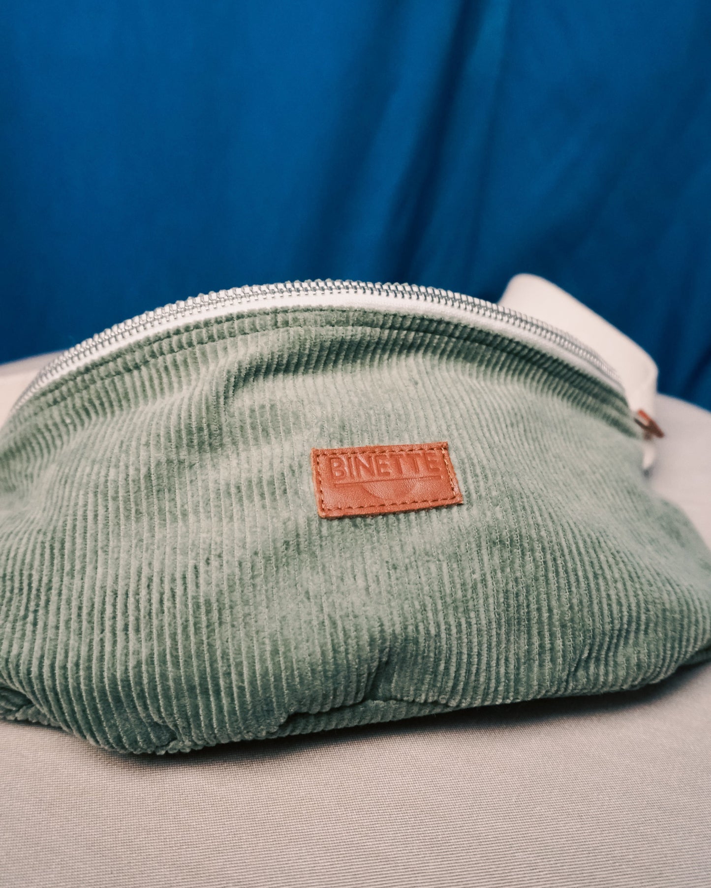 Détail du logo Binette brodé sur le sac banane en velours côtelé upcyclé – Une finition soignée qui reflète l’engagement de la marque pour une mode plus durable et responsable.