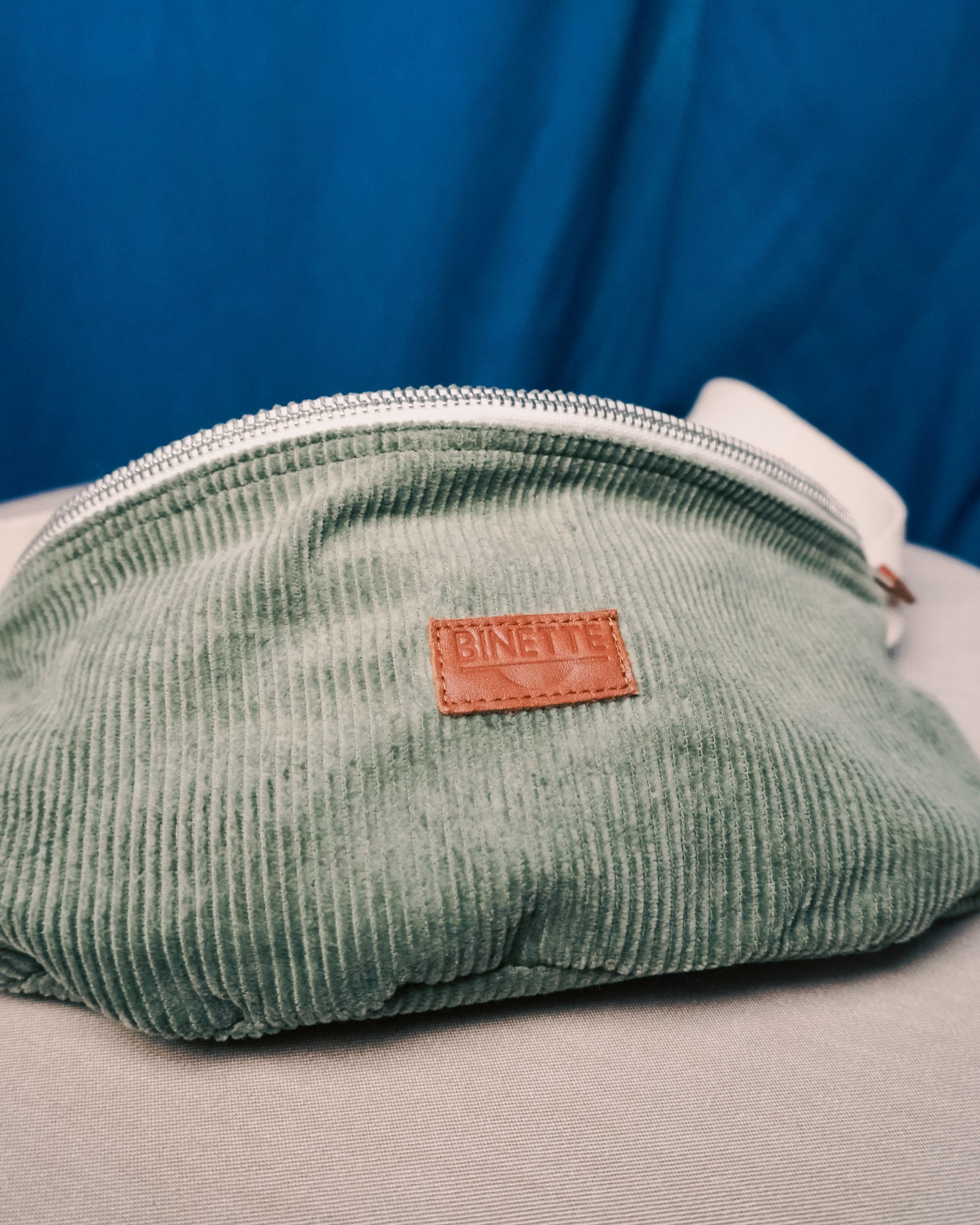 Détail du logo Binette brodé sur le sac banane en velours côtelé upcyclé – Une finition soignée qui reflète l’engagement de la marque pour une mode plus durable et responsable.