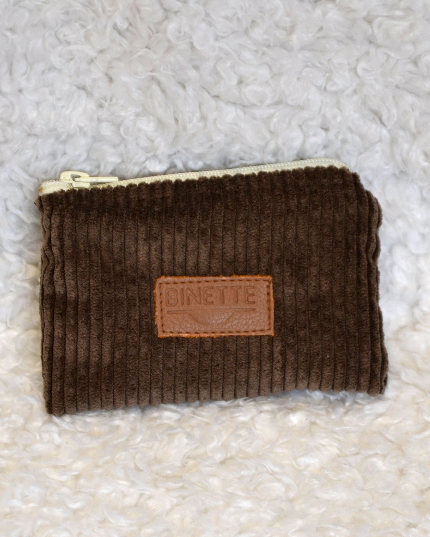 Porte-monnaie marron chocolat en velours côtelé avec logo Binette en cuir et fermeture blanche.