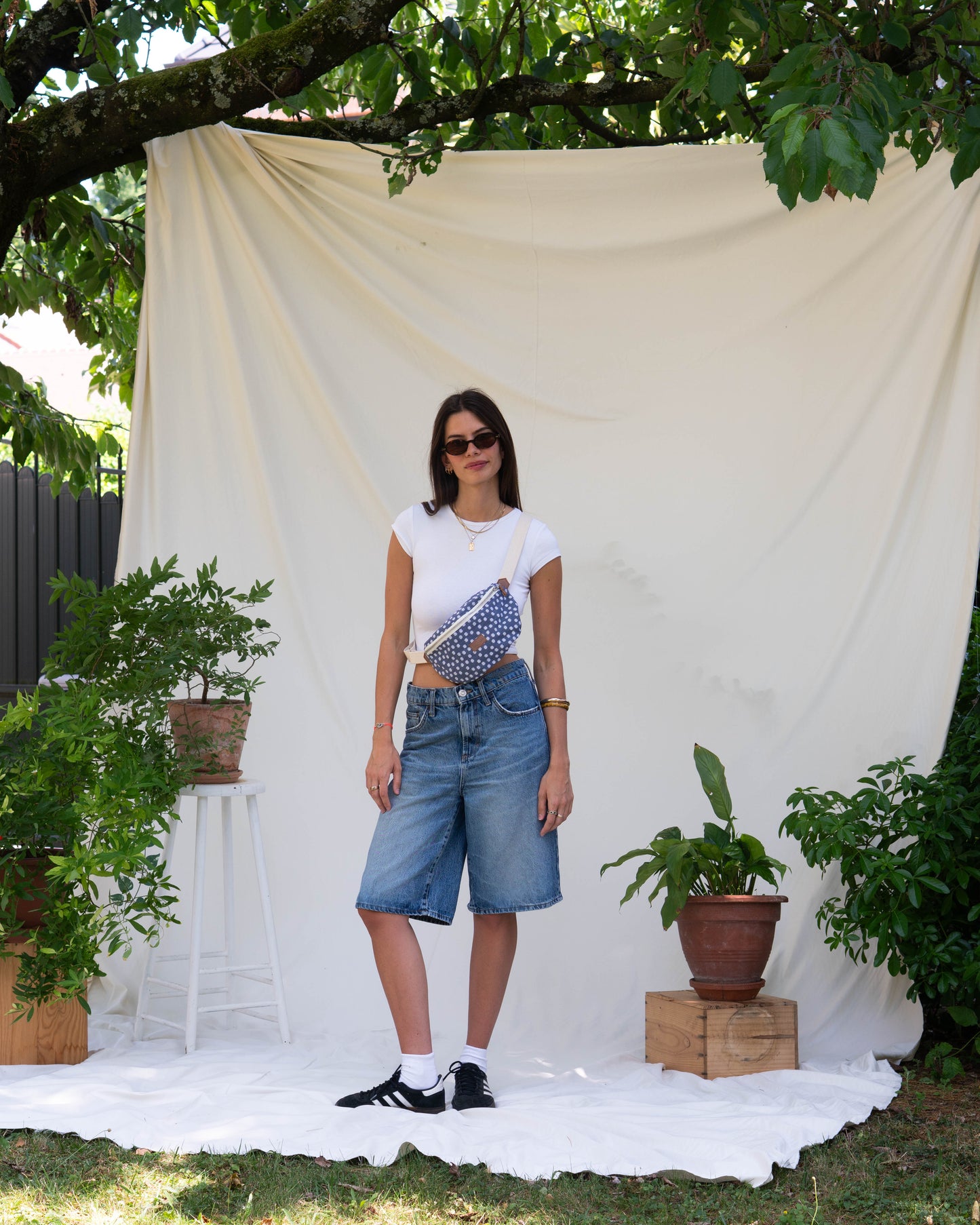 jeune femme debout portant un sac banane ecoresponsable bleu marine fleuris et upcyclé
