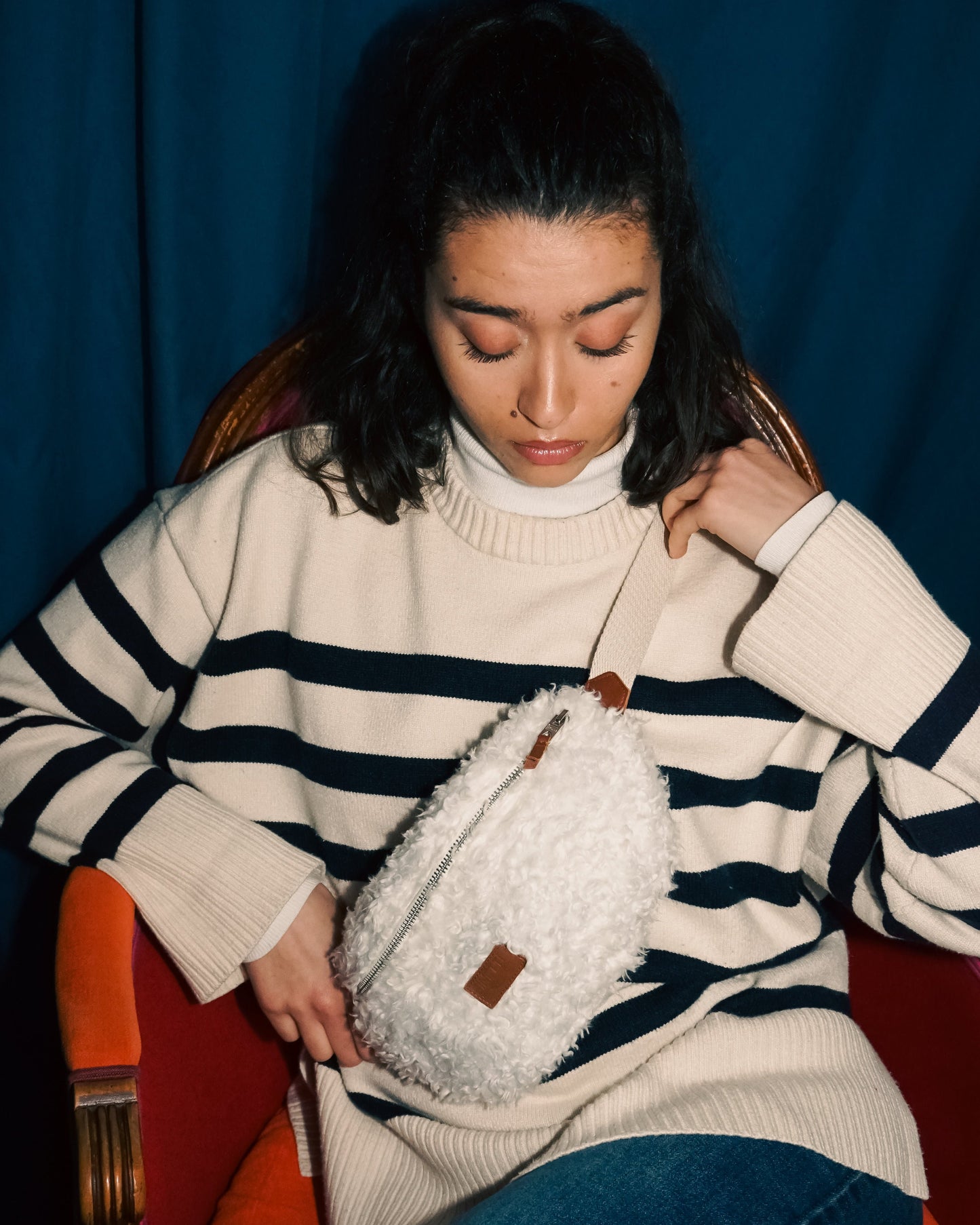 Jeune femme brune regardant sa banane upcyclée en molleton blanc fabriquée par une marque française écoresponsable Binette.