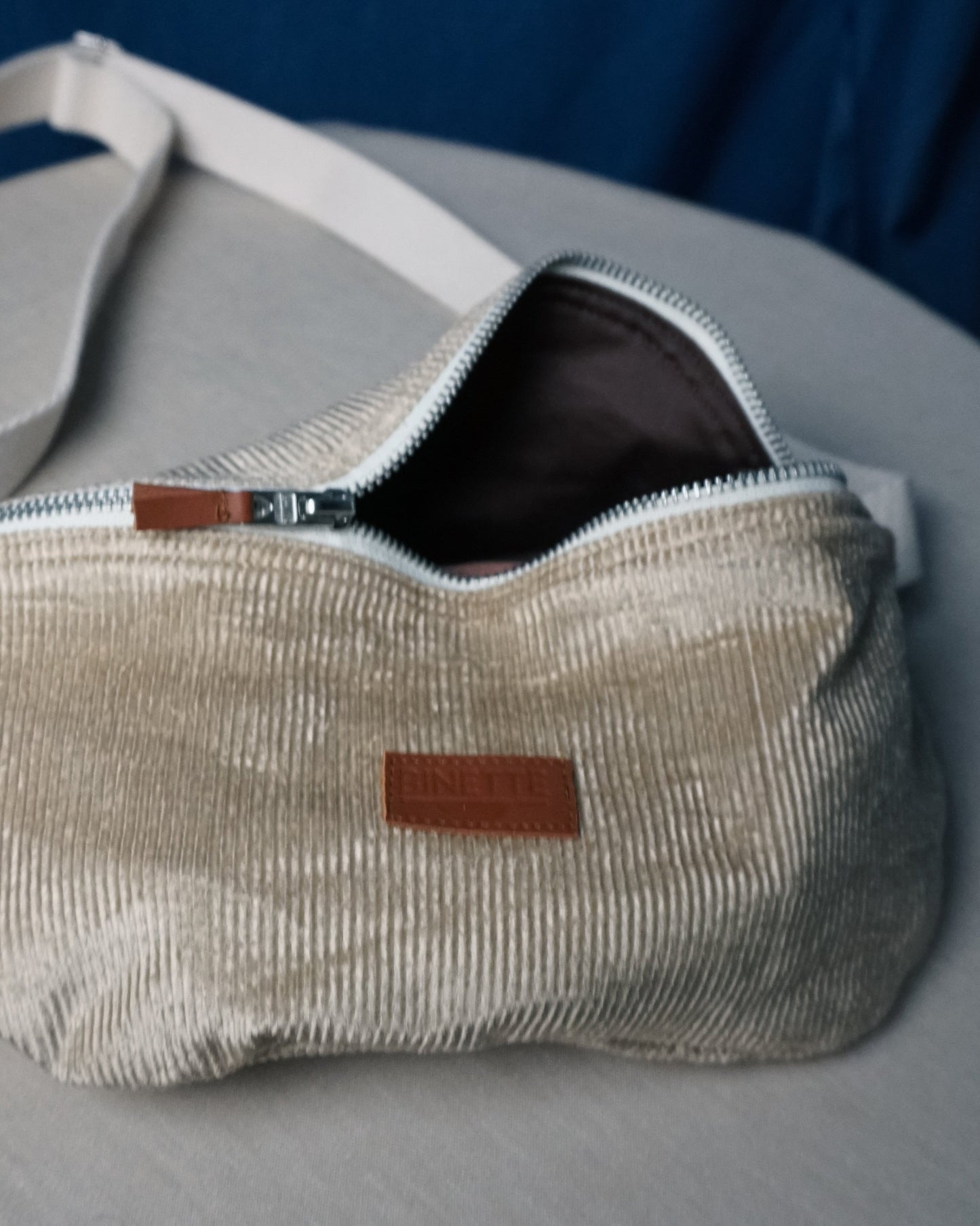 Sac banane upcyclé beige sable sangle blanche fabriqué par une marque française écoresponsable Binette. Mode éthique quais parisiens mode responsable tissu upcyclé chutes de tissus dormants voués à être jetés ou brûlés accessoires upcyclés pratiques tendances et éco-friendly