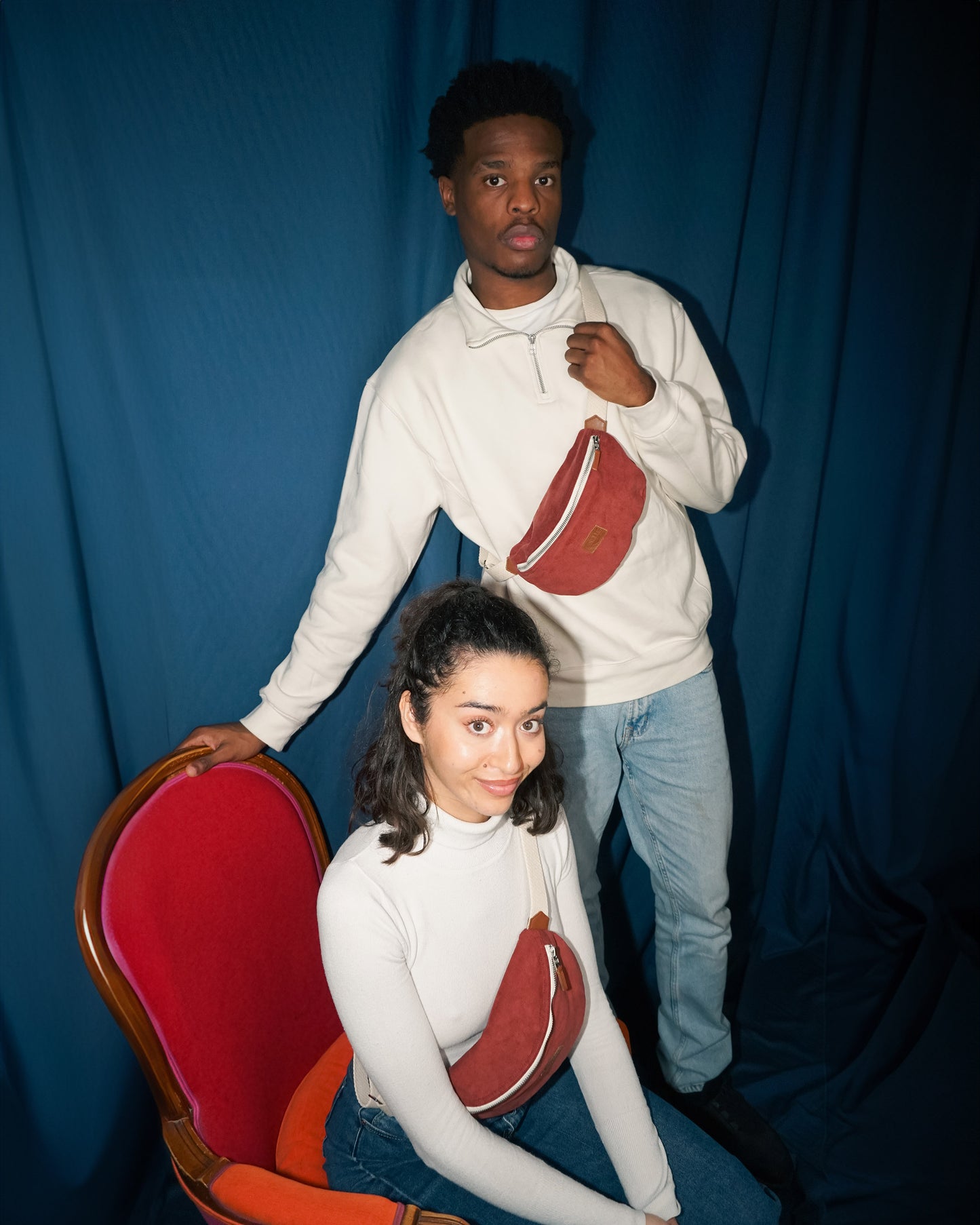 Homme et femme en duo, portant la banane Binette rouge en velours côtelé. 
Accessoire conçusà partir de tissu upcyclé, pour un engagement durable et une mode responsable.