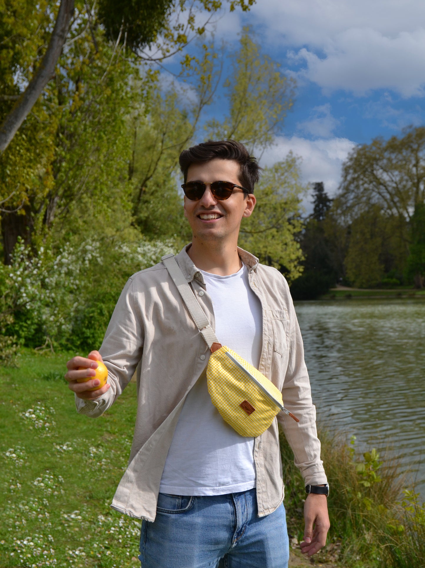 Jeune homme brun portant un sac banane binette écoresponsable jaune motif vichy  fait par une marque française. 
