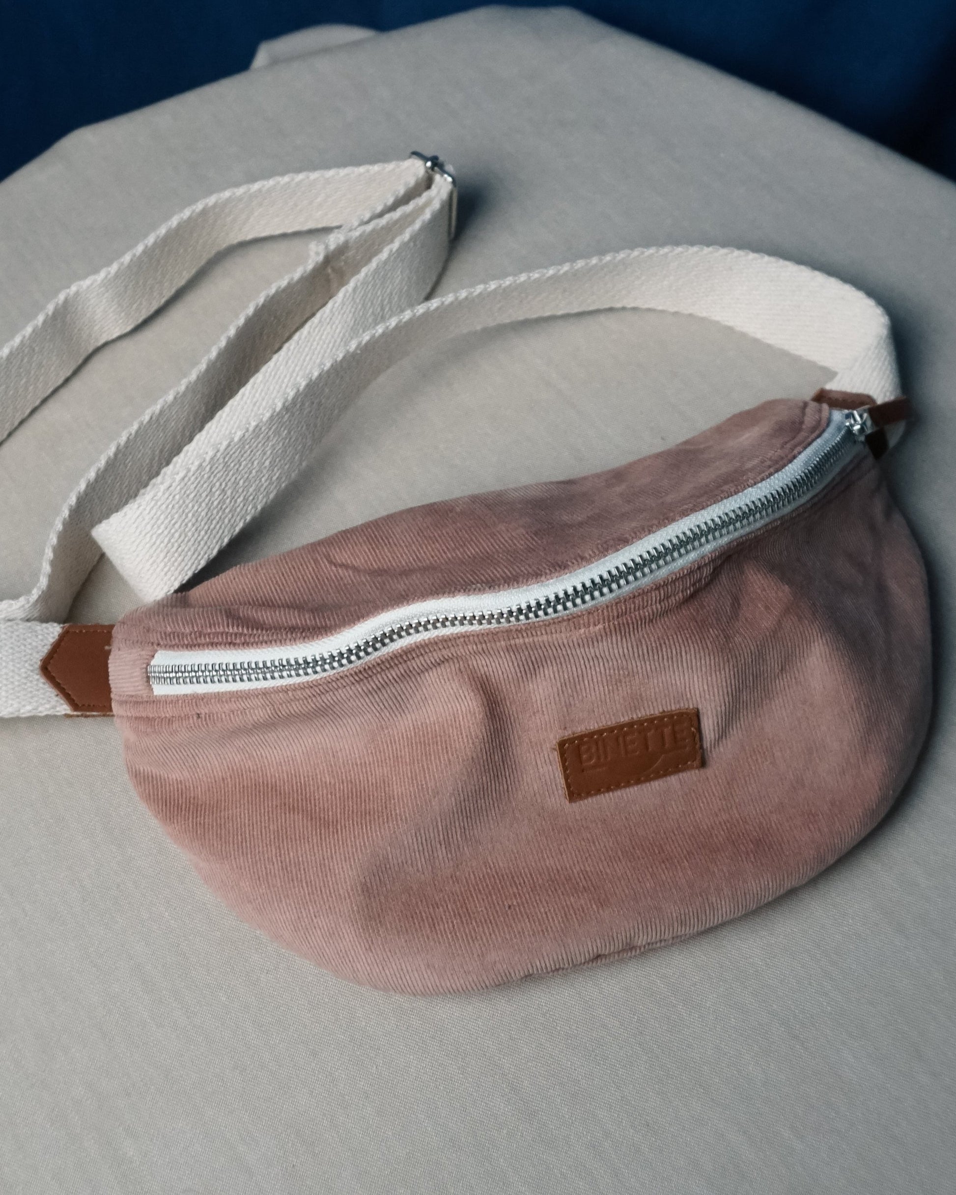Détail du logo Binette brodé sur le sac banane en velours côtelé rose clair upcyclé – Une finition soignée qui reflète l’engagement de la marque pour une mode plus durable et responsable.