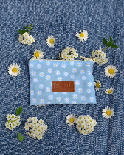 La pochette Marguerite Bleue est l'accessoire polyvalent par excellence. Avec sa doublure en coton bleu marine, elle offre un espace élégant pour ranger vos petits indispensables avec style. Parfaitement assortie au reste du pack, elle complète votre look avec finesse.