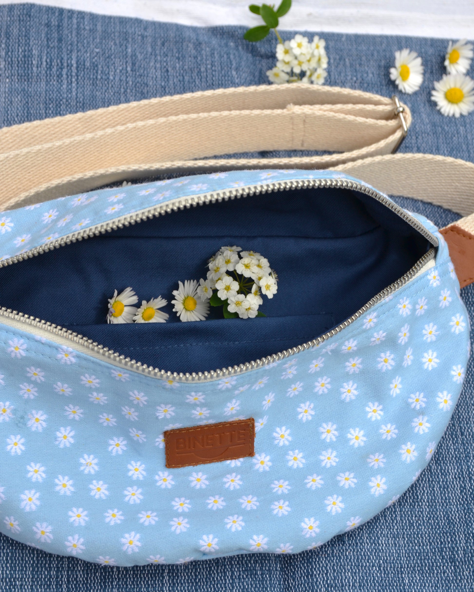 le sac banane Marguerite Bleue se démarque avec sa doublure en coton bleu marine. Pratique et élégant, il devient rapidement un incontournable pour ceux qui recherchent un accessoire à la fois fonctionnel et esthétique.