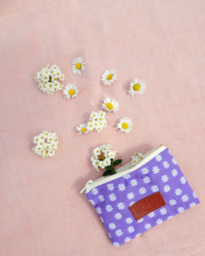 La Pochette Marguerite Violette se dévoile dans toute sa splendeur dans cette photo en gros plan. Son motif floral délicat et sa couleur violette captivent le regard, ajoutant une touche de charme bohème à cet accessoire polyvalent. 