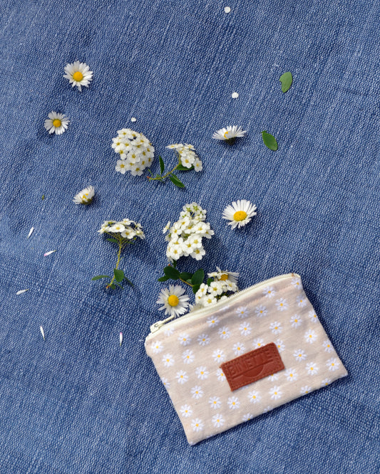 Découvrez la pochette Marguerite Beige dans toute sa splendeur ! Cette photo en gros plan met en valeur son motif floral délicat et sa couleur neutre, parfaits pour ajouter une touche de charme bohème à votre look estival.