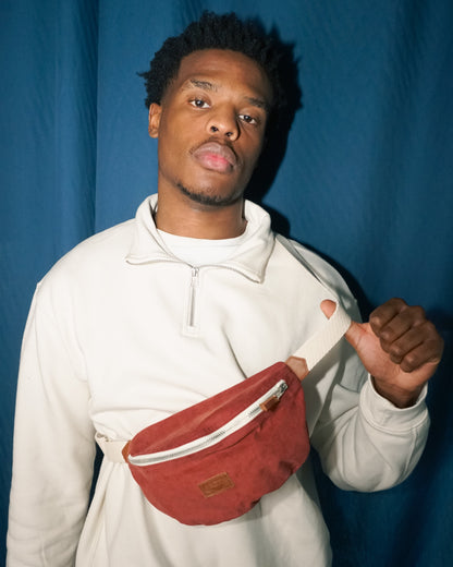 Modèle de face portant le sac banane Binette en velours côtelé rouge. Accessoire écoresponsable en tissu upcyclé qui allie douceur, style et engagement pour une mode durable.