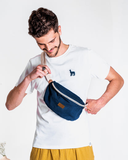 Jeune homme brun portant un Sac banane Binette écoresponsable fabriqué à partir de chutes de tissus dormants voués à être jetés ou brûlés bleu marine collection binette une marque française écoresponsable de sacs banane upcyclés et accessoires uniques et tendances luttant pour le gaspillage textile, en collaboration avec perus pour la collection de sacs banane fabriqué avec l'innovante matière Ecovero et coton recyclé