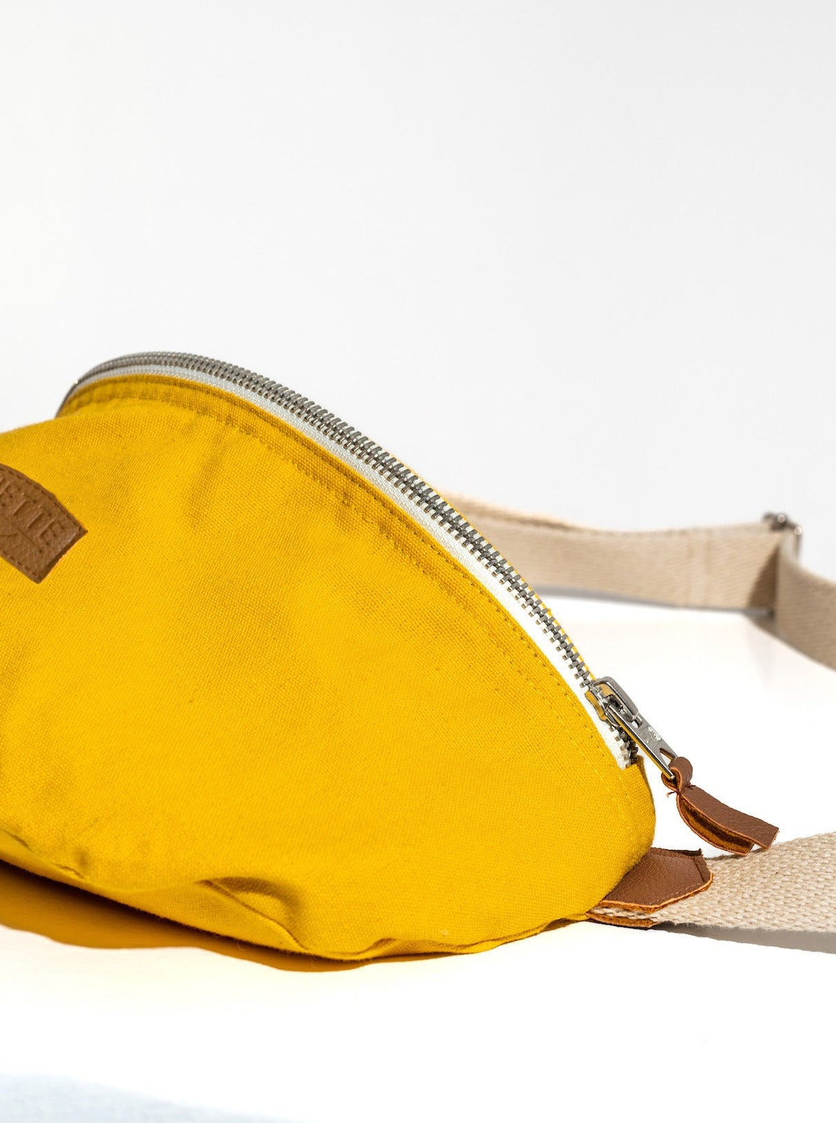 zoom sur le Sac banane Binette upcyclé à partir de chutes de tissus dormants voués à être jetés ou brûlés revalorisés par Binette la marque française écoresponsable de sacs banane et accessoires écoreponsables, éthiques, tendances, jolis, ecoresponsable, avec un faible impact environnemental et luttant contre le gaspillage textileécoresponsable pour un sac banane upcyclé jaune collection binette x perus