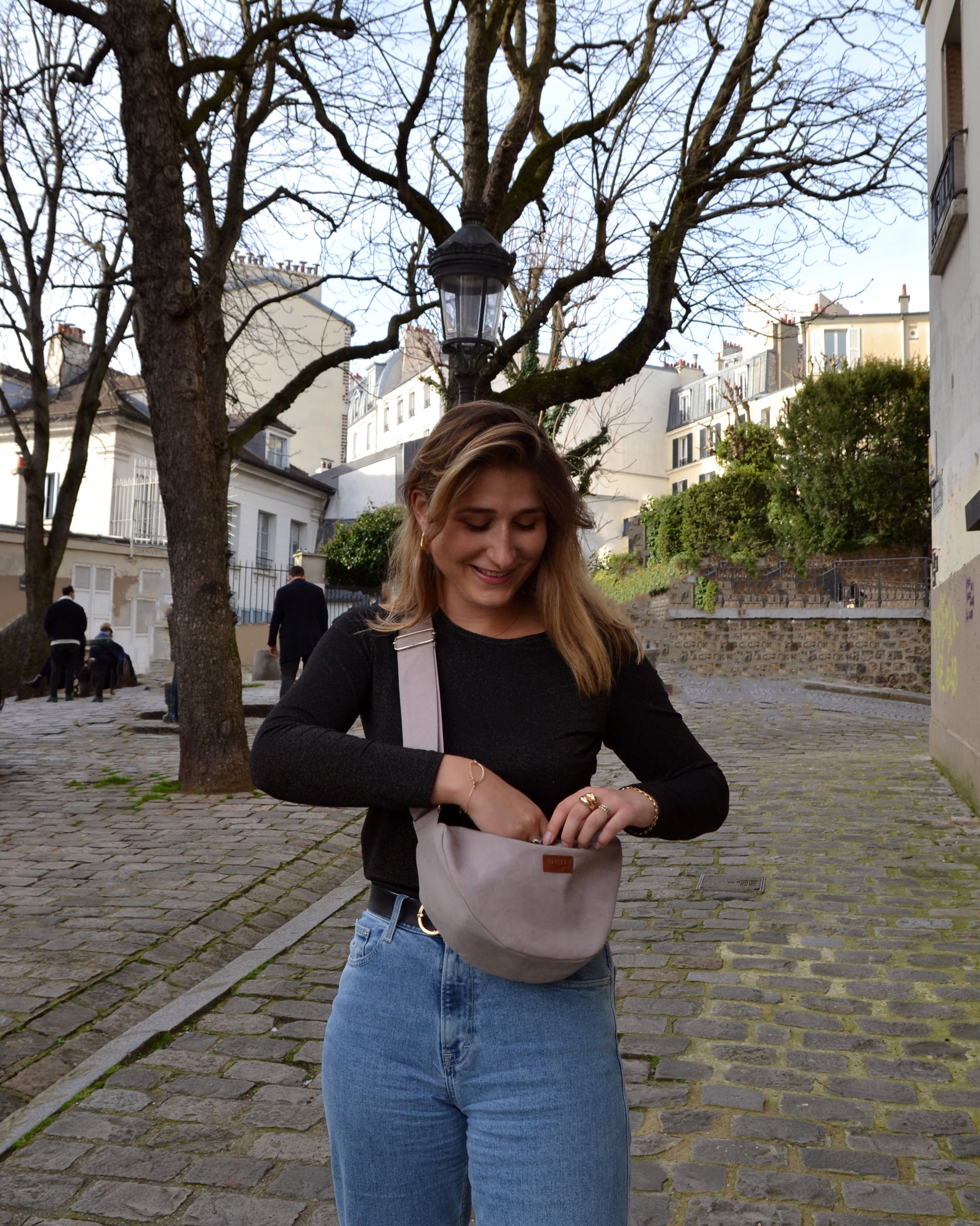 Cette photo met en lumière une femme audacieuse arborant le Sac Banane Demi-Lune gris lilas avec assurance. Son attitude confiante témoigne du caractère tendance de ce sac, qui s'adapte parfaitement à son style personnel. Que ce soit pour une journée de balade en ville ou une soirée entre amis, ce sac devient rapidement un accessoire indispensable pour celles qui recherchent à la fois style et fonctionnalité.