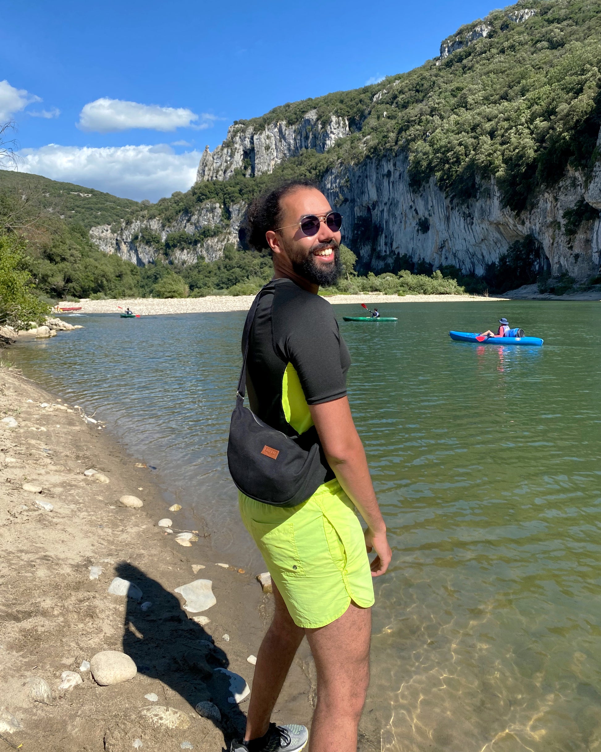 un homme porte le Sac Banane Demi-Lune noir upcyclé made in france au lac de come. Son attitude déterminée témoigne de la polyvalence de ce sac, qui peut être porté de manière décontractée en bandoulière ou à la taille pour un look plus tendance. Avec sa contenance généreuse et son design éco-responsable, ce sac devient rapidement un compagnon de choix pour toutes les aventures urbaines.