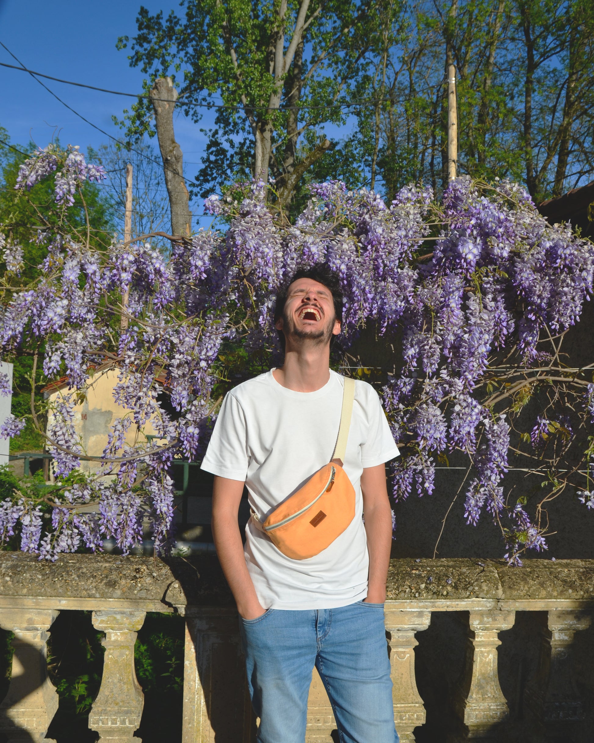 Capturant le style décontracté d'un homme moderne, cette photo le montre portant la Binette Pêche en bandoulière avec assurance. Son attitude détendue témoigne de la polyvalence de ce sac, qui s'adapte à tous les styles. Avec la Binette Pêche, l'homme moderne peut affirmer son sens du style avec élégance.