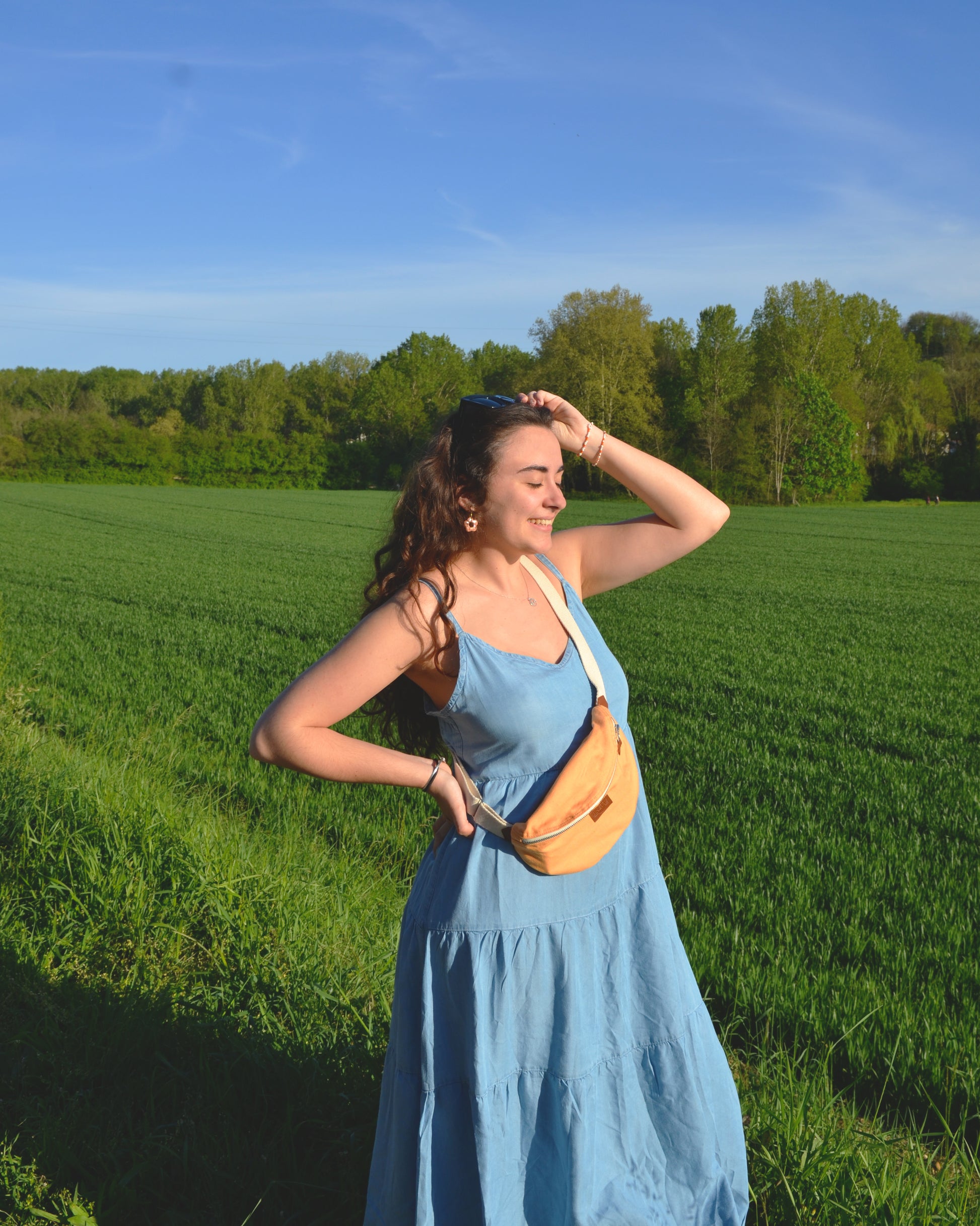 Capturant l'essence de l'avee nture estivale, une femme active porte la BinettPêche avec détermination. Son attitude confiante témoigne de la polyvalence de ce sac, idéal pour les escapades en plein air. Avec la Binette Pêche, la femme moderne peut explorer le monde en toute liberté.