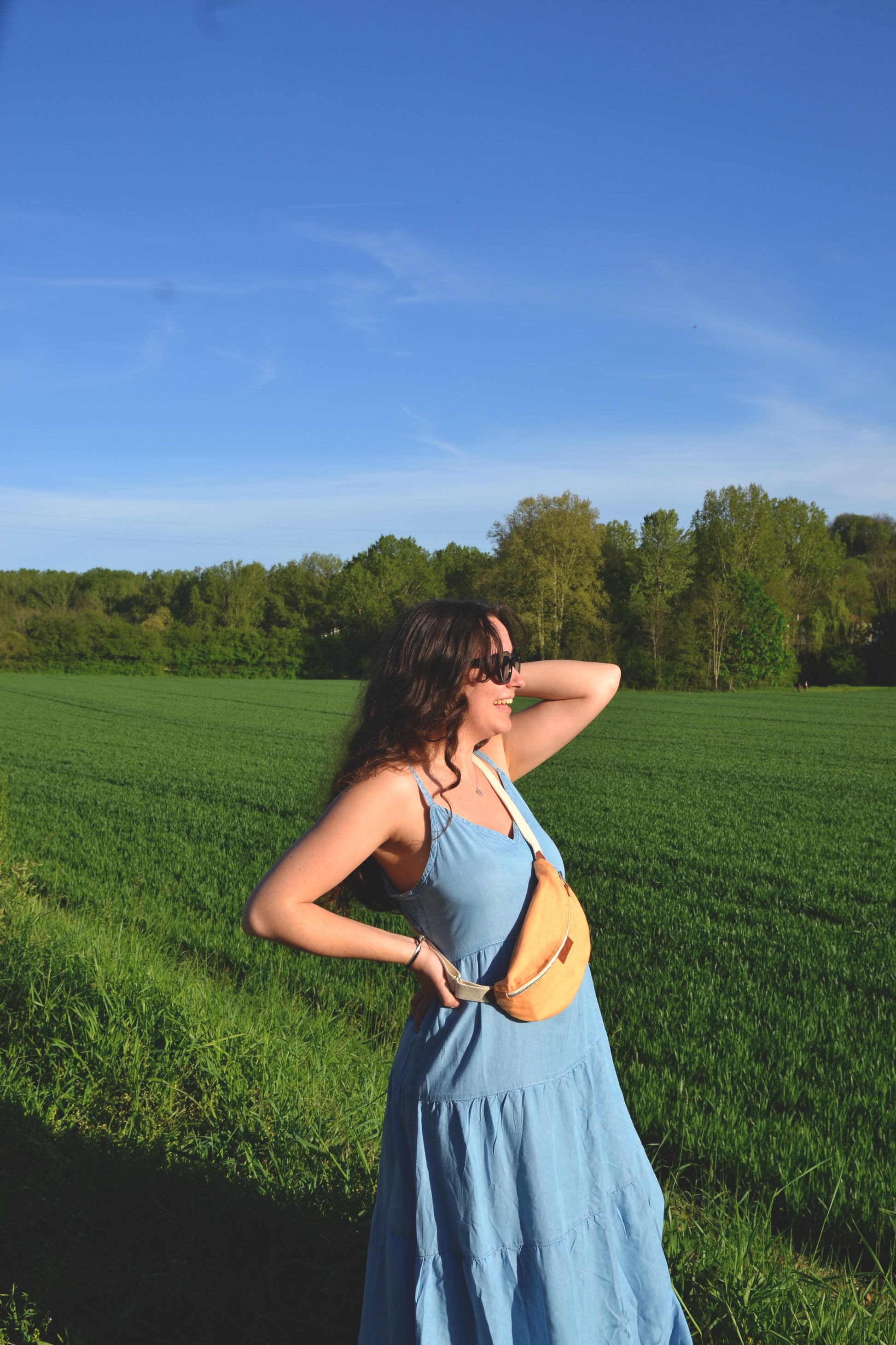 Dans cette image dynamique, une femme énergique porte la Binette Pêche en bandoulière tout en se déplaçant avec aisance. Son allure décontractée reflète la praticité de ce sac, parfait pour une journée bien remplie. Avec la Binette Pêche, la femme active peut jongler entre style et fonctionnalité sans compromis.