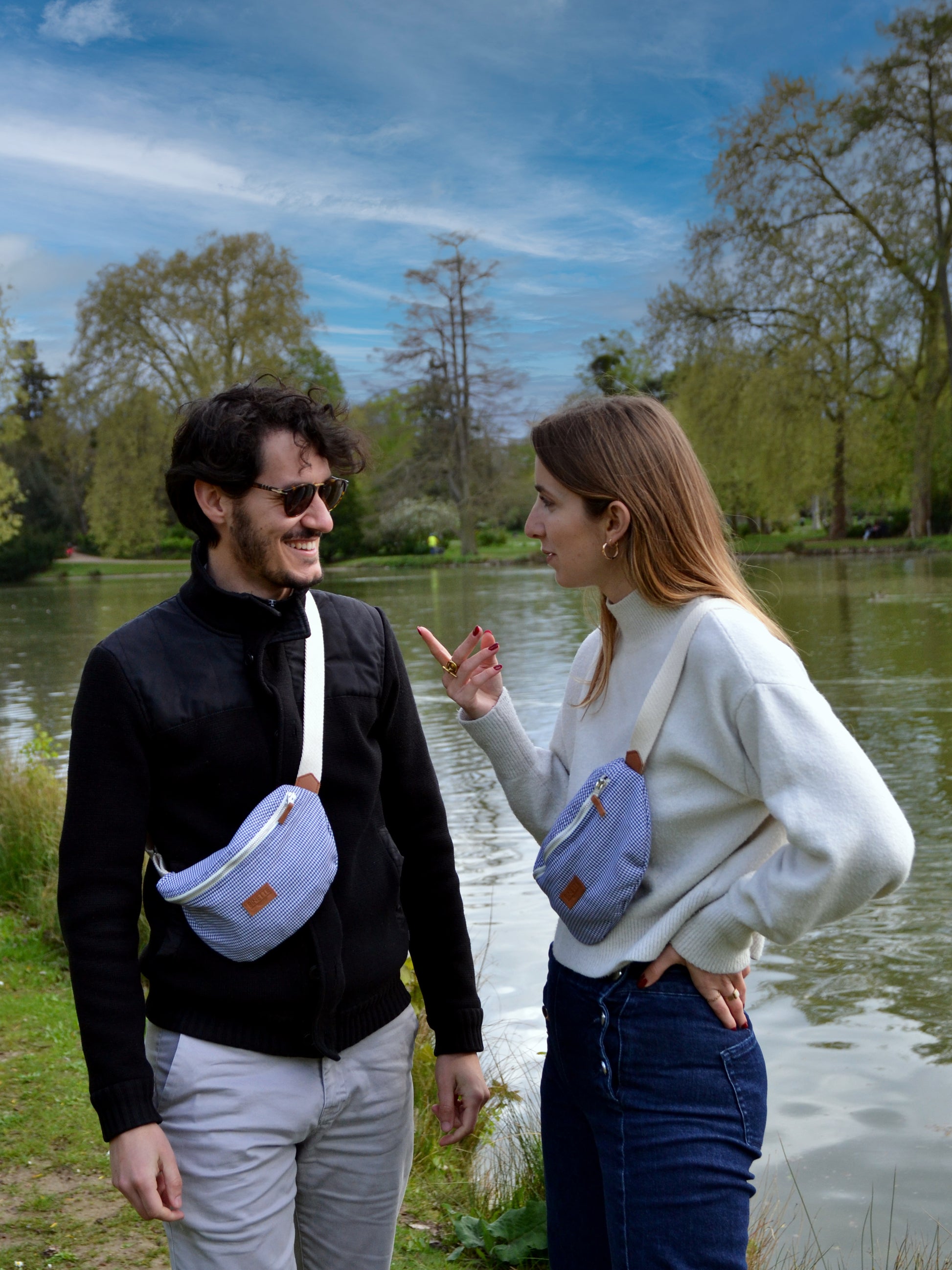 Jeune femme blonde et jeune homme brun portant un sac banane Binette upcyclé Iris motif pieds de poule fabriqué à partir de chutes de tissus dormants et revalorisé par Binette la marque française écoresponsable de sacs banane et accessoires upcyclés pratiques, tendances, écoreponsable, éthiques, durable et avec un impact environnemental réduit tout en luttant contre le gaspillage textile.