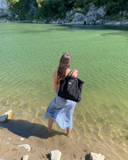 jeune femme au lac de come portant le sac cabas noir upcyclé made in france à froufrous écoresponsables de binette marque française de sacs banane accessoires maroquinerie upcyclé écoresponsable tendance et uniques.