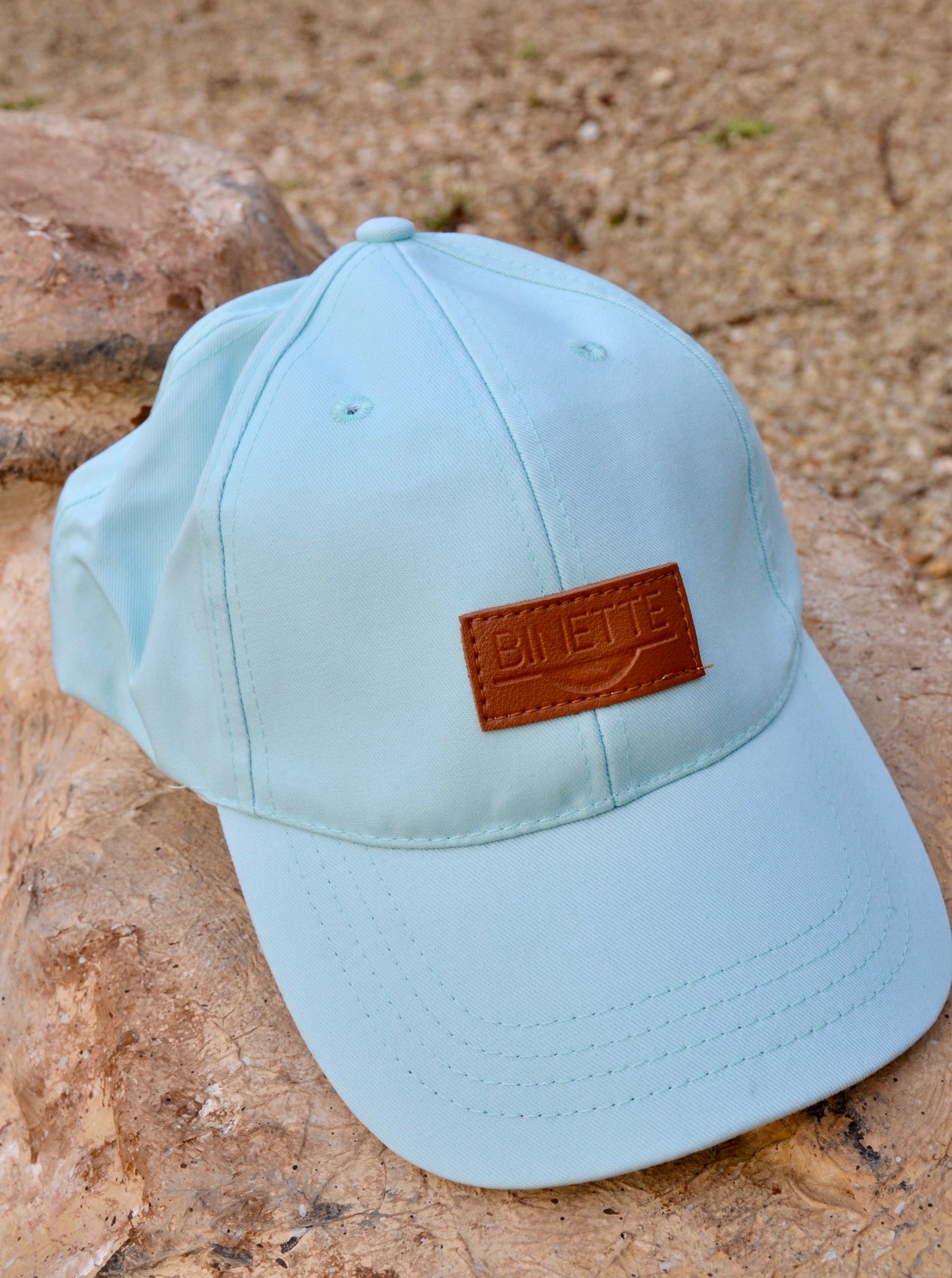 Casquette couleur vert d'eau de la collection binette été posée sur un rocher, un produit upcyclé et écoresponsable fabriqué par une marque française